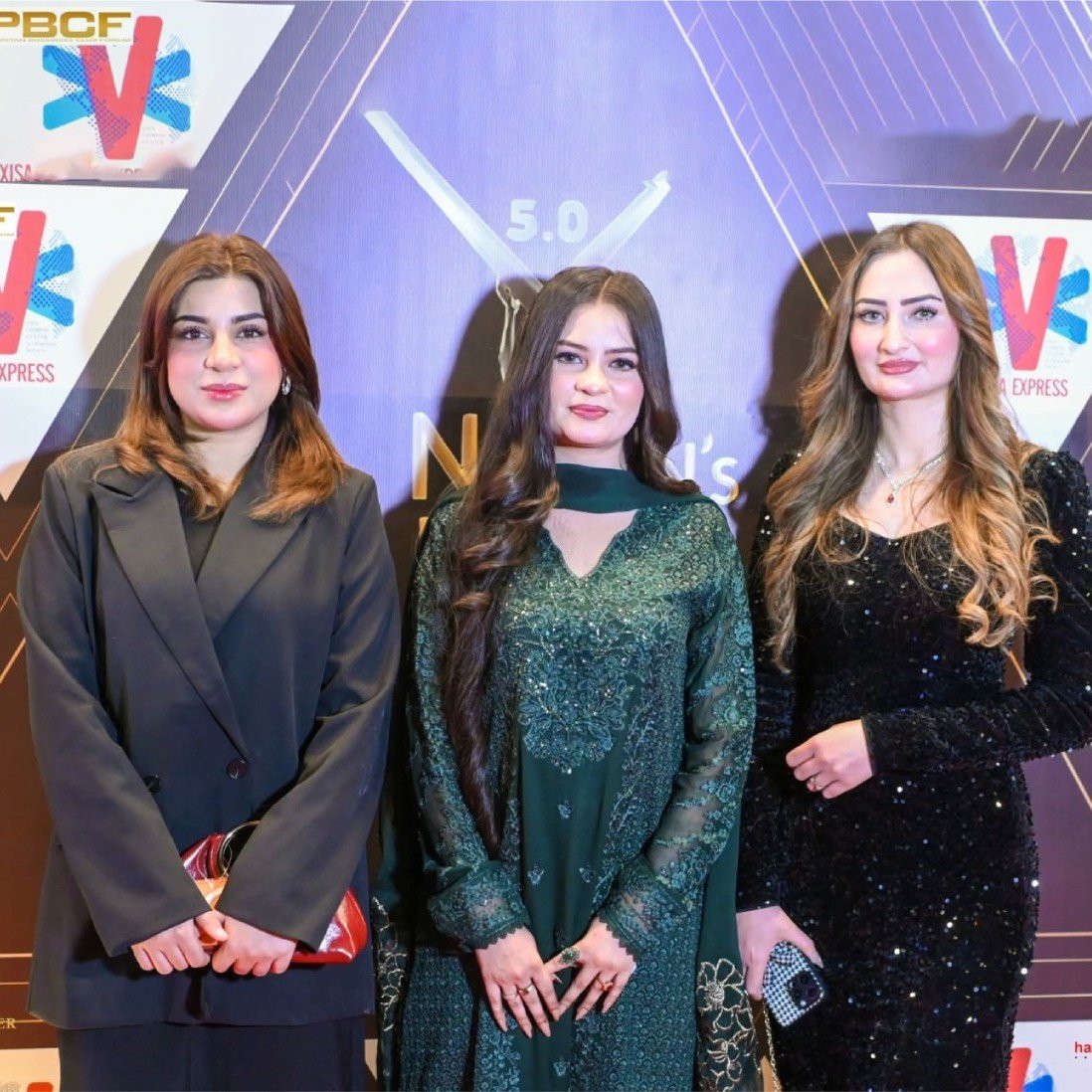 Mrs. Mughal in green traditional attire at PBCF Nation's Leader Awards 5.0 backdrop