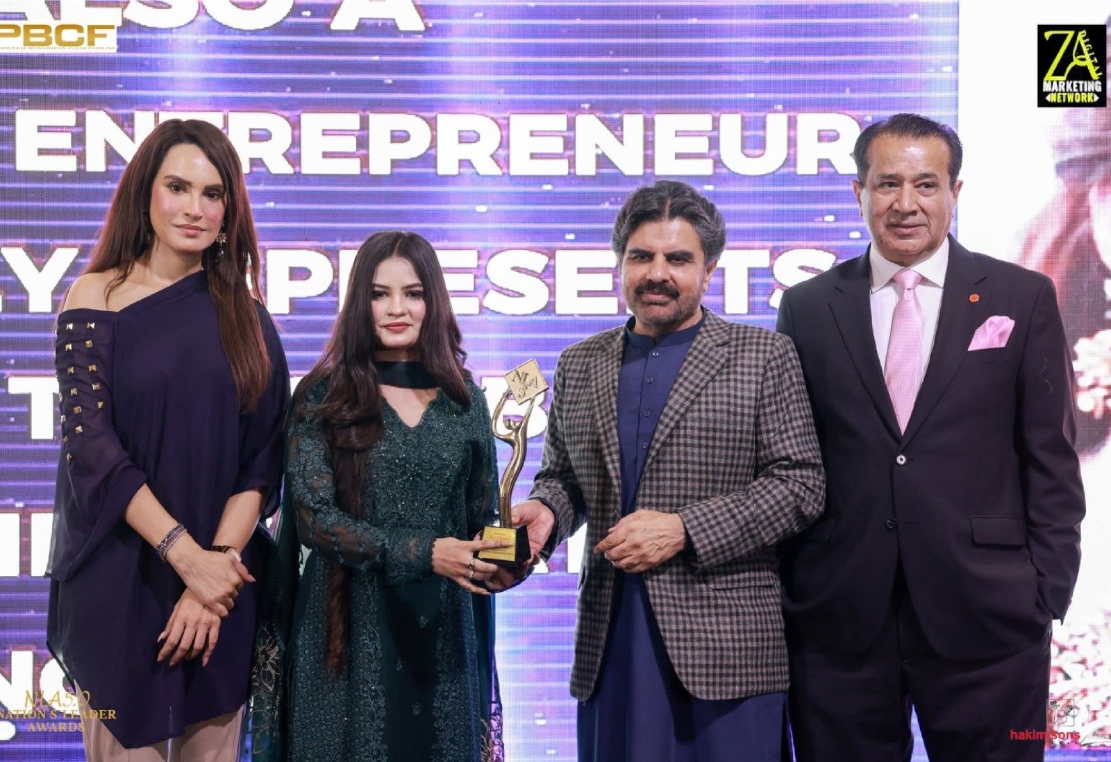 Mrs. Mughal receiving Nation's Leader Award on stage from dignitaries and Sindh Minister Syed Nasir Hussain Shah